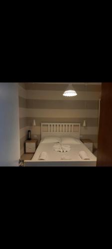 una camera da letto con un letto bianco e una luce sopra di Vila DB 
