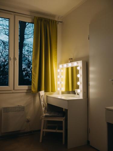 a bathroom with a sink with a mirror and a chair at Vila Na Landeku in Ostrava