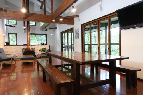 a living room with a wooden table and benches at Bears Den Mountain Lodge in Hakuba