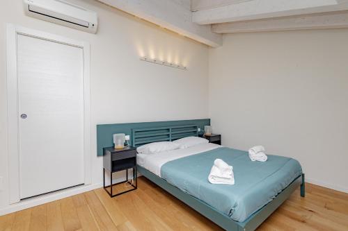 um quarto branco com uma cama e uma porta em CityCenter em Bérgamo