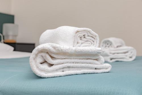 uma pilha de toalhas sentadas em cima de uma cama em CityCenter em Bérgamo