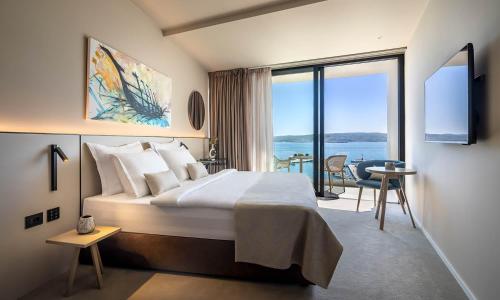 um quarto de hotel com uma cama e uma grande janela em Aminess Younique Narrivi Hotel em Crikvenica