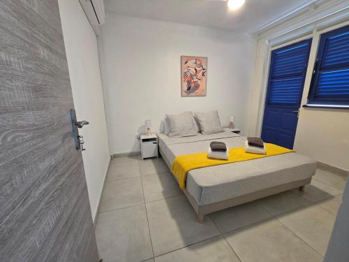 a bedroom with a bed with a yellow blanket at Les Terrasses de la Wallon Paprika in Les Trois-Îlets
