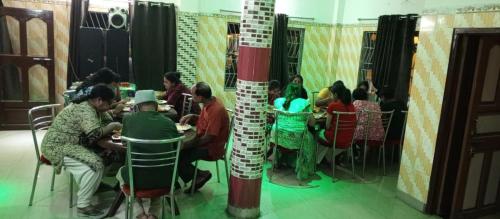 a group of people sitting at tables in a restaurant at Sea Land Mandarmani in Mandarmoni