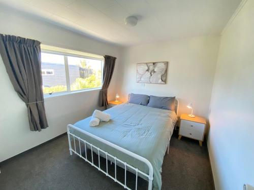 a bedroom with a bed with a teddy bear on it at Coastal Charm in Patons Rock in Rangihaeata