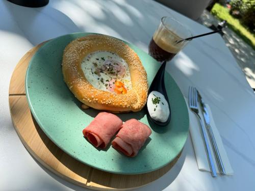 a plate of food with a pretzel and a drink at Kenta Mountain Hotel & Gastrobar in Portariá