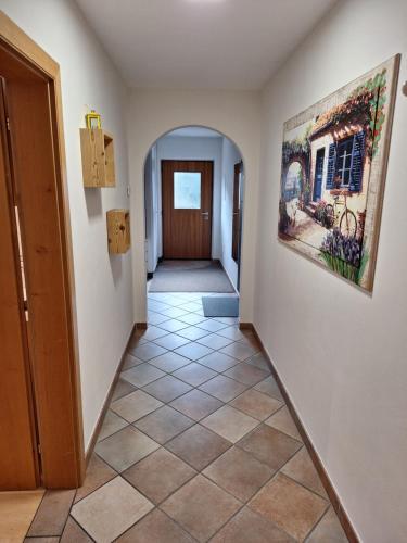 a hallway with a tile floor and a painting on the wall at Apartments Insam in Santa Cristina in Val Gardena
