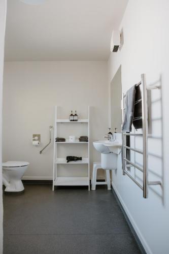 a white bathroom with a sink and a toilet at Amber Court Motel Nelson in Nelson