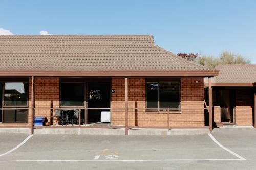 a brick building with a parking lot in front of it at Amber Court Motel Nelson in Nelson