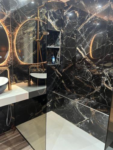 a bathroom with a black marble wall at Haddad in Persan