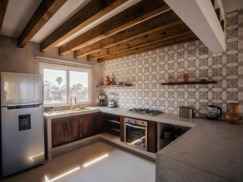 a kitchen with a stainless steel refrigerator and a window at Casona del Sol in Puerto Escondido