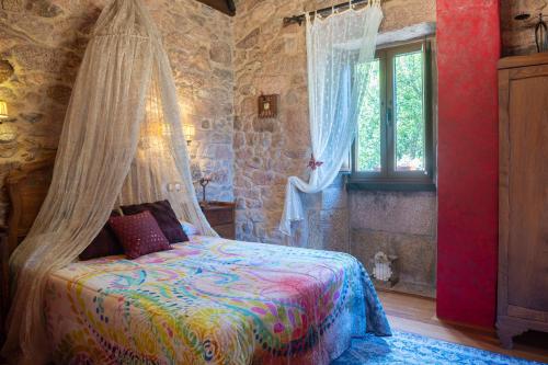 1 dormitorio con 1 cama con mosquitera en Casa A Laxe, en O Pindo