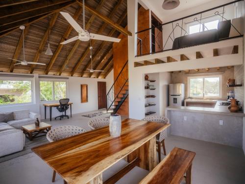a kitchen and living room with a wooden table at Casona del Sol in Puerto Escondido