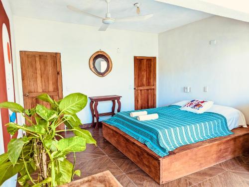 ein Schlafzimmer mit einem Bett und einer Pflanze in der Unterkunft posada el pescador in Mazunte