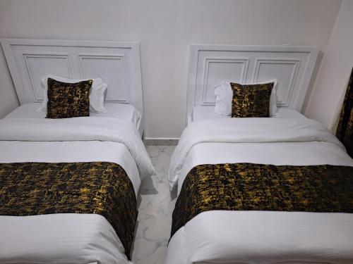 two beds in a room with white walls at Mellow Homes 3 - Own compound in Kitengela 