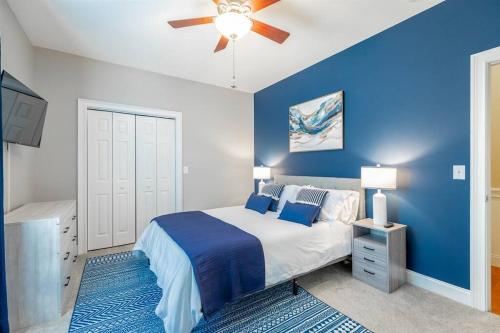 a blue bedroom with a bed and a ceiling fan at Pickleball - Pool - Hot Tub - Gym - BBQ in Cenchat