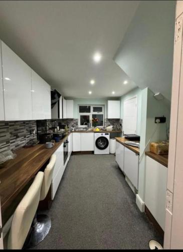 a large kitchen with white cabinets and a stove at Holiday double room in Nottingham