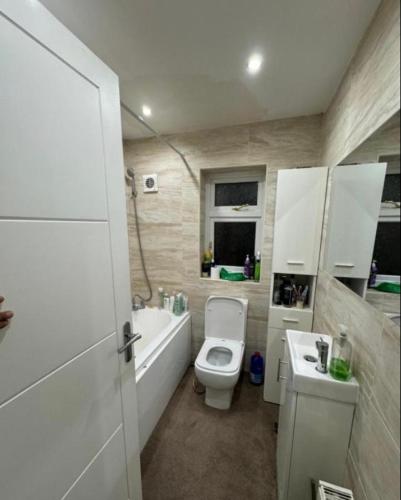 a bathroom with a toilet and a tub and a sink at Holiday double room in Nottingham