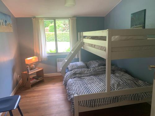 1 dormitorio con litera, 1 cama y 1 silla en Villa de 3 chambres avec piscine partagee sauna et jardin clos a Ecuras, en Écuras