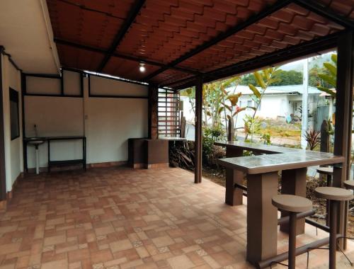 a large room with a table and stools at Cabaña Dream House in Pejibaye