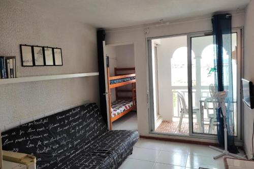 un salon avec un canapé et une porte coulissante en verre dans l'établissement Superb apartment close to the sea in Barcarès, au Barcarès