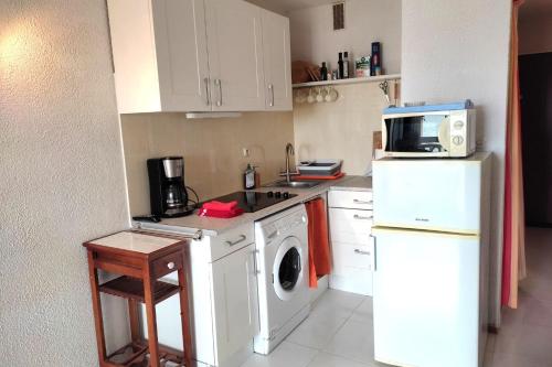 une cuisine avec un lave-linge et un micro-ondes dans l'établissement Superb apartment close to the sea in Barcarès, au Barcarès