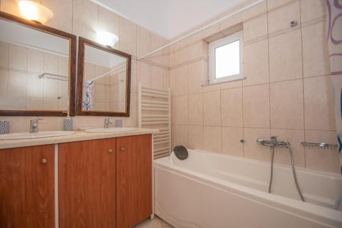 a bathroom with a tub and a sink at Afrodite's Oasis Villa by "elite" in Akrotiri