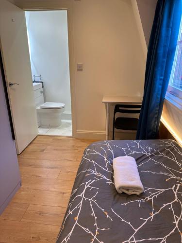 a bedroom with a bed with a towel on it at Not very quiet but best Location in London