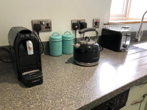 a kitchen counter with a coffee maker and a toaster at Iris Cottage in Whitstable
