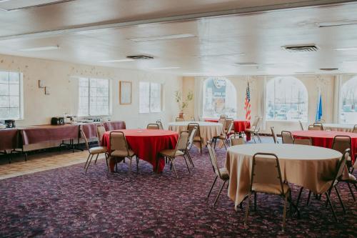 uma sala cheia de mesas e cadeiras com toalha de mesa vermelha em Carson City Plaza Hotel em Carson City