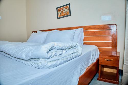a bedroom with a bed with a wooden headboard at Arusha Serene Apartments in Arusha