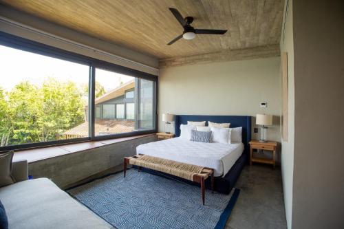 a bedroom with a bed and a large window at Casa Borrega, Luxury and Design in Higuera Blanca