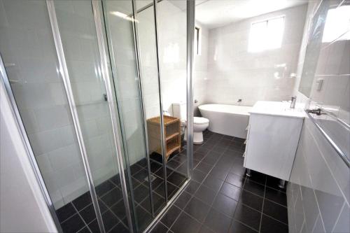 a bathroom with a shower and a sink and a toilet at Beach Break at Hat Head - 22 Bay Street in Hat Head