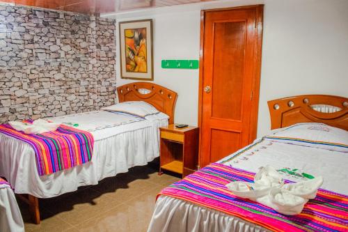 HOTEL PACHAKUTEQ في ماتشو بيتشو: غرفه فندقيه سريرين في غرفه