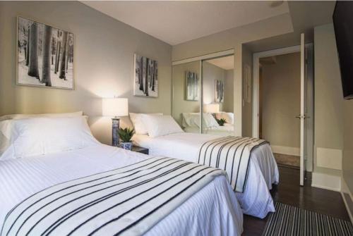 a bedroom with two beds and a mirror at Residence Inn by Soho in Toronto