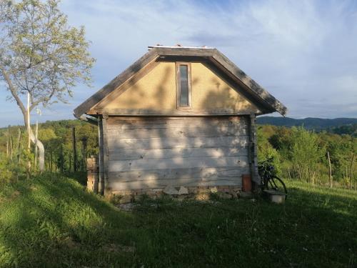 une vieille maison assise sur une colline herbeuse dans l'établissement Deda Vinko Off Grid Cabin, à Ključ