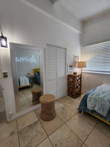 a bedroom with a bed and a room with a mirror at Moeʻuhane Kai Beach Front Home in Hauula