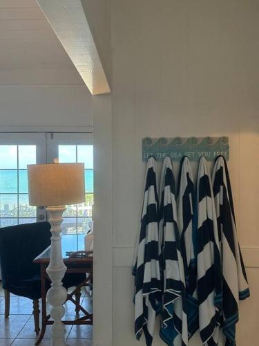 a room with a table with a lamp and a curtain at Moeʻuhane Kai Beach Front Home in Hauula