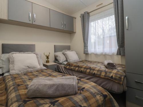 sypialnia z 2 łóżkami i oknem w obiekcie Cotswold Cwtch w mieście Evesham