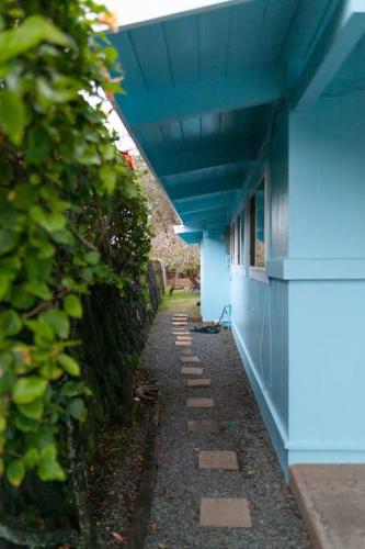 a blue building with a blue roof and a pathway at Moeʻuhane Kai Beach Front Home in Hauula