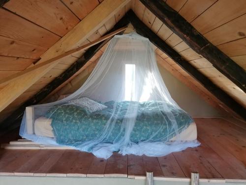 - un lit mansardé avec moustiquaire dans l'établissement Deda Vinko Off Grid Cabin, à Ključ