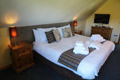 Corncrake Cottage في Manish: غرفة نوم عليها سرير وفوط