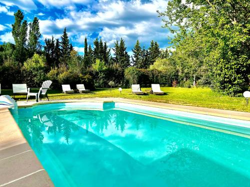 una piscina con sillas y un patio con árboles en Domaine Plan des Devens, en Roussillon