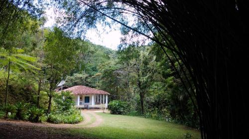 una casa en medio de un bosque con un patio en Chalé na floresta com varanda en Ouro Preto