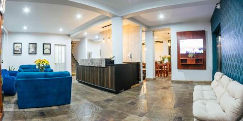 a living room with blue couches and a kitchen at Mirador del Monasterio in Arequipa