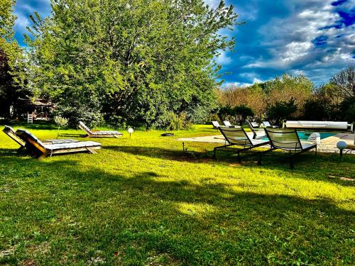 a group of chairs and a bench in the grass at Domaine Plan des Devens in Roussillon