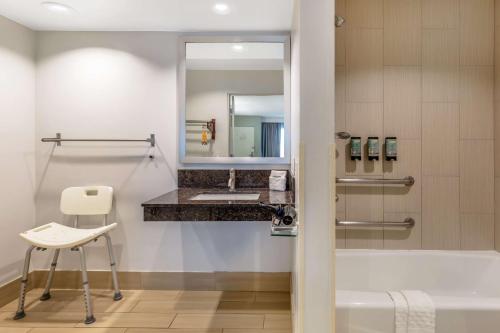 bagno con vasca, lavandino e specchio di Best Western Inn at Palm Springs a Palm Springs