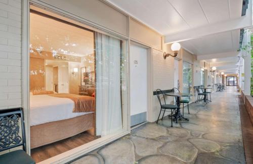 a bedroom with a bed and a table and chairs at Best Western Plus Cairn Croft Hotel in Niagara Falls