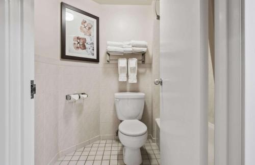 a bathroom with a toilet and towels in it at Best Western Plus Cairn Croft Hotel in Niagara Falls