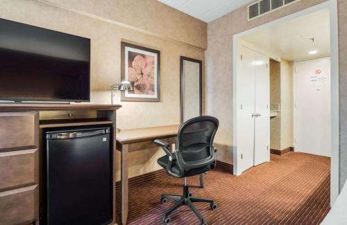 a hotel room with a desk and a chair at Best Western Plus Cairn Croft Hotel in Niagara Falls